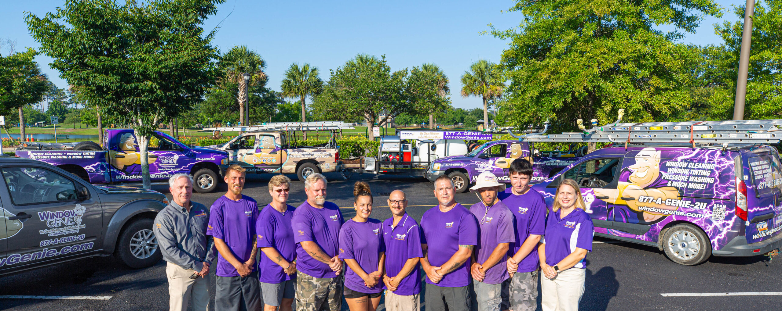 Picture of staff of Window Genie standing outside in front of their company vehicles